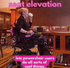 Woman in Power wheelchair elevated to table drinking coffee 